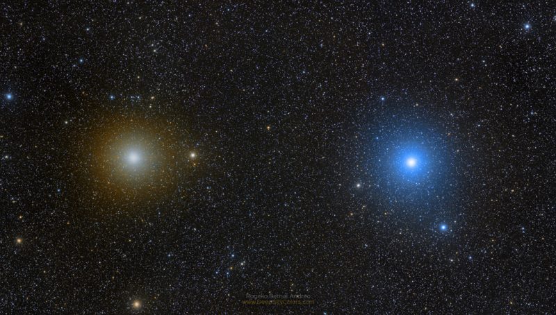Dos estrellas muy brillantes sobre un fondo de muchas estrellas más débiles.  Pollux aparece como una estrella dorada clara, mientras que Castor aparece azul-blanco.