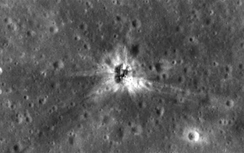 Superficie con cráteres con salpicaduras brillantes y rayos que irradian desde el centro.