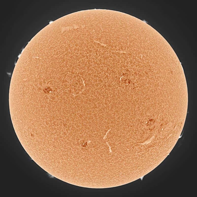 El sol, visto como una gran esfera naranja con una superficie moteada.